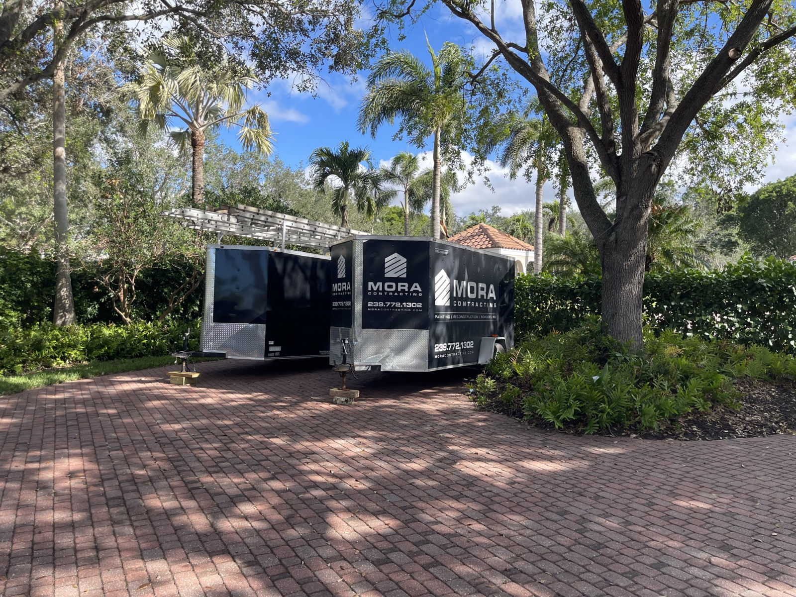 MORA Contracting branded equipment trailers on site at a Southwest Florida community